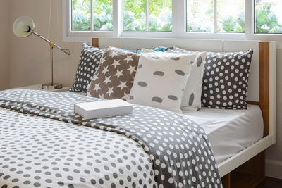 Table and chairs on bed by window at home