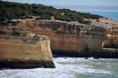 Scenic view of rock formation by sea against sky