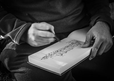 Midsection of man holding paper