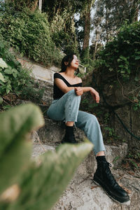 Portrait of young woman sitting on rock