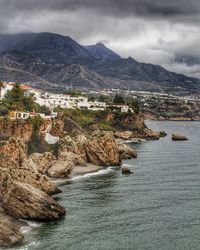 Scenic view of sea and mountains against sky