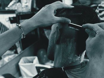 Close-up of barber shaving man head