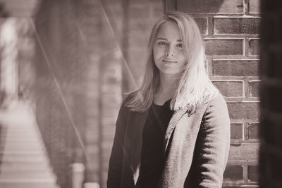 Portrait of beautiful woman standing by architectural columns