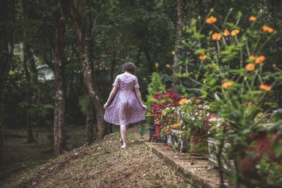 Rear view of woman walking in forest