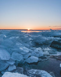 Scenic view of frozen sea against sky during sunset