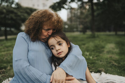 Senior woman kissing granddaughter at park