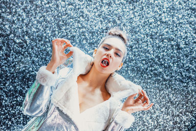 Close-up portrait of young female model with crystal in mouth