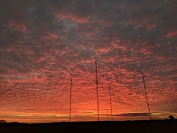 Silhouette trees against dramatic sky during sunset