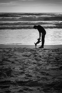 Silhouette man on beach against sky