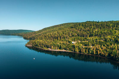 Scenic view of lake against clear blue sky