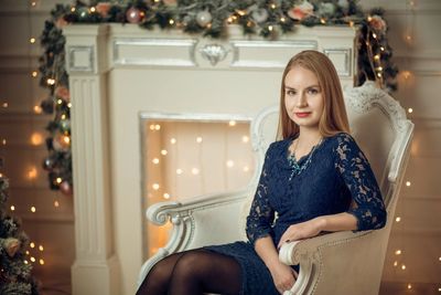 Young woman sitting in christmas tree