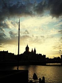 City at waterfront against cloudy sky