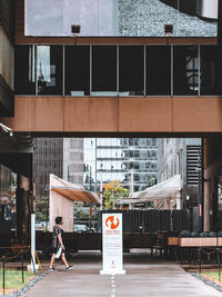 People on street by building in city