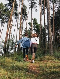 Full length of friends on tree trunk in forest