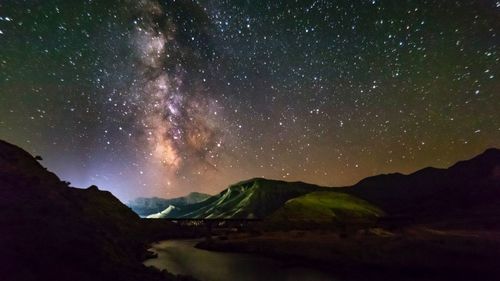 Scenic view of mountains against sky at night