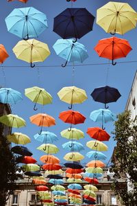Low angle view of umbrellas hanging against clear sky