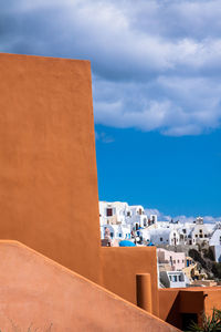 Buildings against cloudy blue sky at oia