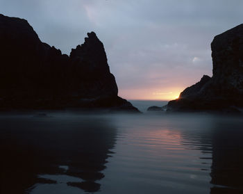 Scenic view of rock formation in sea against sky