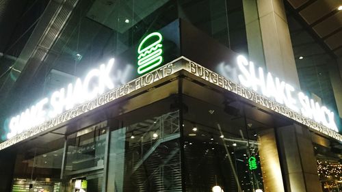 Low angle view of illuminated sign in city at night