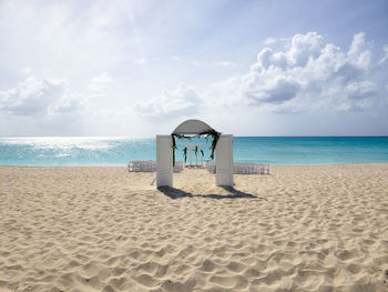 Lifeguard hut on beach against sky