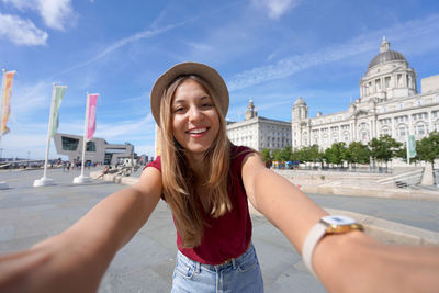 Beautiful young woman takes selfie picture in the city centre of liverpool, england.