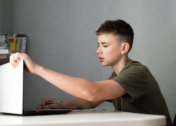 Teenage boy using laptop for study, online education concept