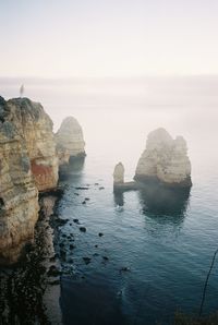 Rock formation in sea against sky on a foggy morning. shot on 35mm kodak portra 400 film.