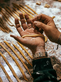 High angle view of a chef rolling dough