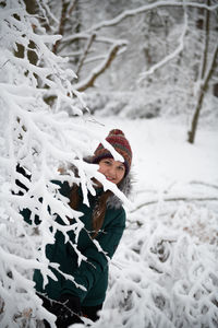 Rear view of woman standing on snow covered field