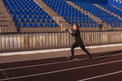 Full length of woman running in stadium