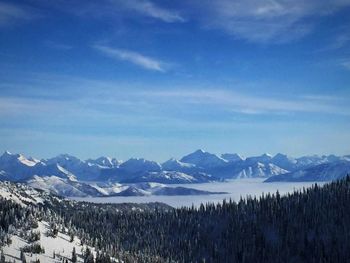 Scenic view of mountain range against blue sky during winter