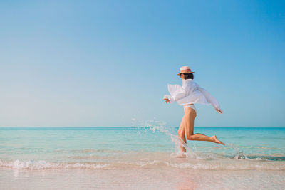 Full length of woman on beach against clear sky