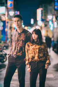 Full length of woman standing in city at night