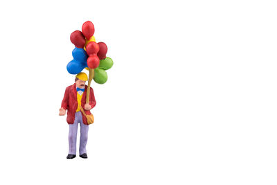 Man holding colorful balloons against white background