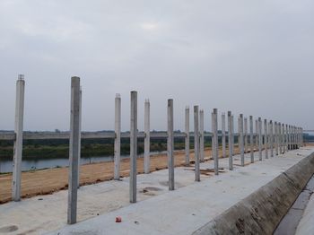 Wooden posts on beach against sky