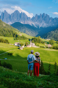 Rear view of boys on field against mountains