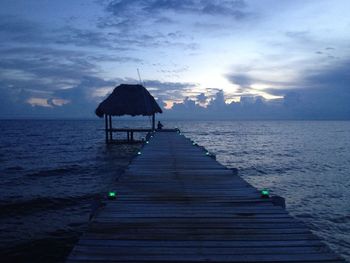 View of pier on sea against cloudy sky