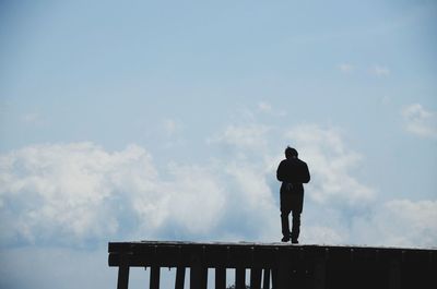 Low angle view of people standing against sky