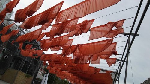 Low angle view of flags hanging against sky