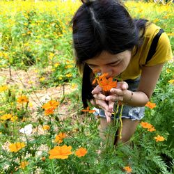 Close-up of girl holding flowers on field