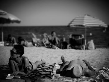 Rear view of woman sitting on beach