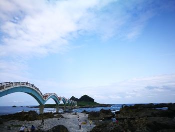 Arch bridge over sea against sky