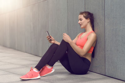 Woman in sports clothing using mobile phone