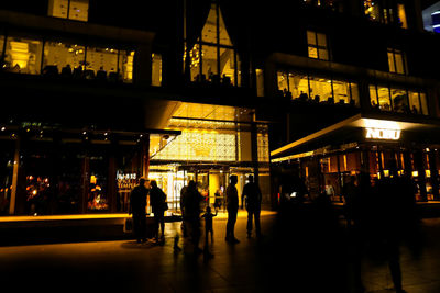 People walking in illuminated building at night