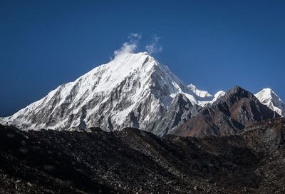 Scenic view of snowcapped mountains against clear blue sky