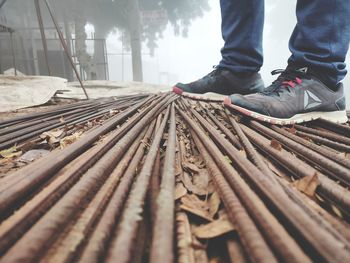 Low section of man standing on wood