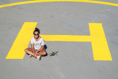 High angle view of teenager girl sitting on helipad