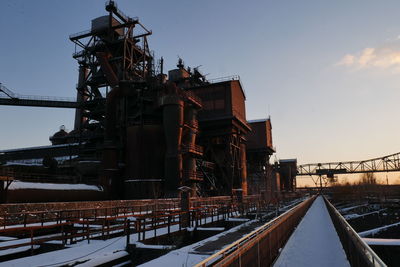 Factory against sky at sunset