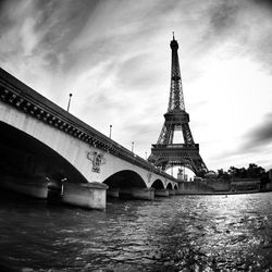 Bridge over river against cloudy sky