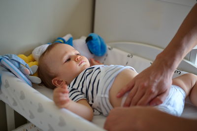 Father changing diapers of cute little baby boy